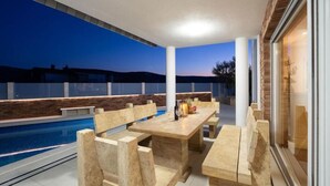 Ein Poolbereich mit Tisch und Stühlen und Blick auf die Landschaft.