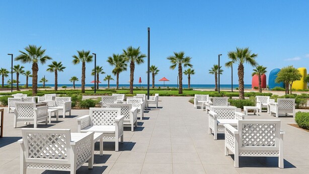 A beachside patio with white outdoor furniture, palm trees, and a clear view of the ocean. - Chalet Porto Said Tourist Resort (Al-Manasrah)