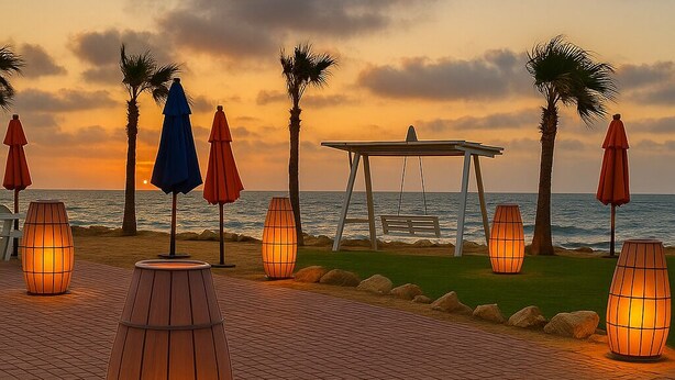 A beachside walkway with palm trees, outdoor seating, and illuminated lanterns. - Luxurious Chalet With Pool Access in Port Said Governorate (Al-Manasrah)