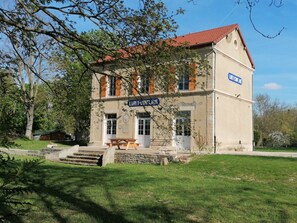 Un bâtiment à deux étages, avec un toit recouvert de tuiles rouges, une enseigne indiquant « LIBRE-LOUIS » et un escalier en pierre menant à l’entrée.