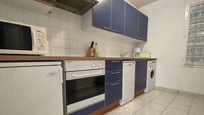 A compact kitchen with a refrigerator, oven, dishwasher, and microwave.
