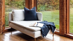 A room with a large window, a white sofa, and a view of autumn foliage. - Glasco Woodstock - 16 Acres with Mountain View. (Saugerties)