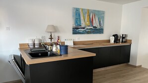 A modern kitchen with a central island, black cabinetry, and a wooden countertop. - House fig trees Roch Priol (Quiberon)