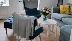 A modern living room with a blue armchair, a white coffee table, and a grey sofa. - House fig trees Roch Priol (Quiberon)