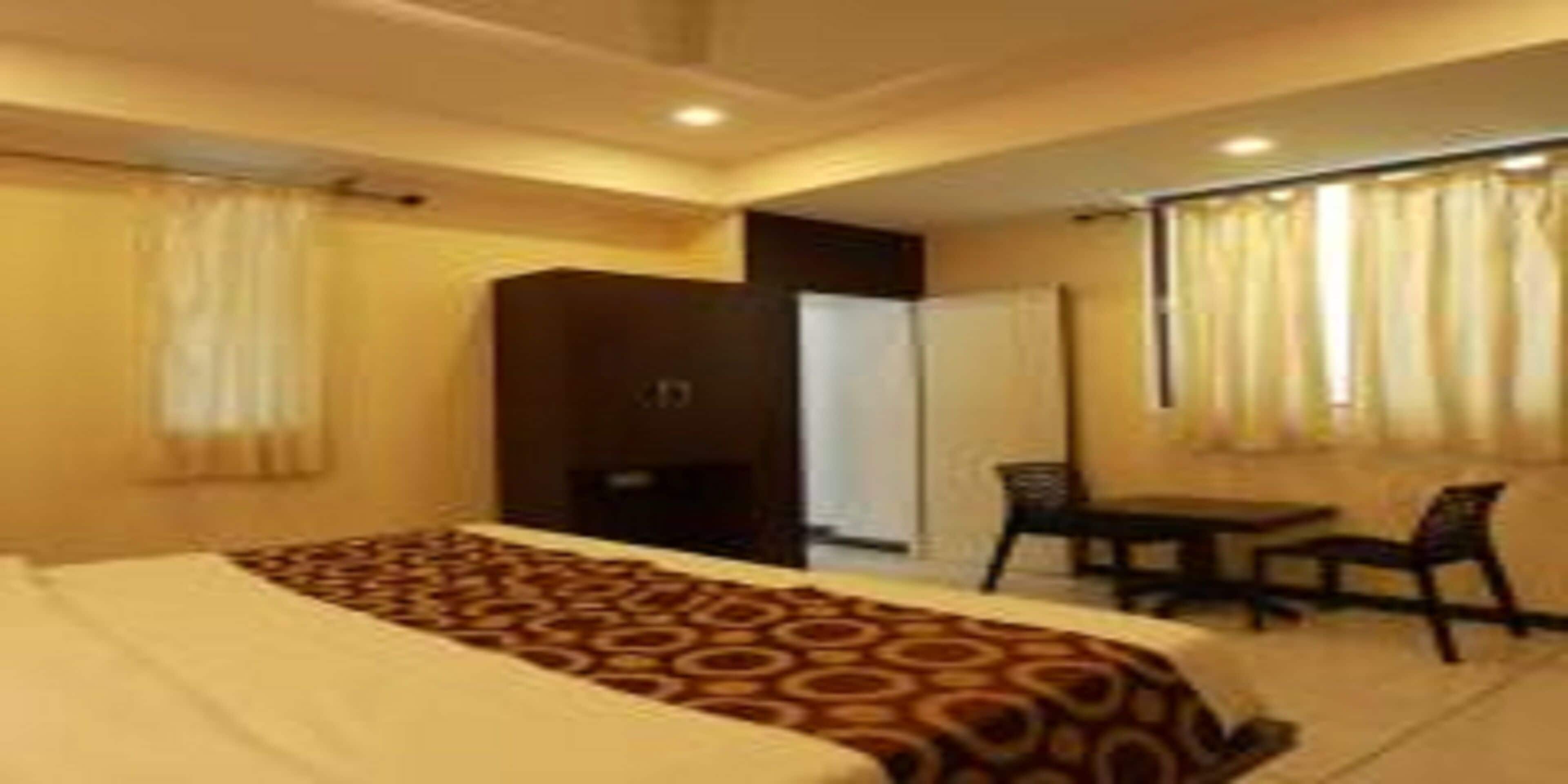 A hotel room with a bed, a desk, and a chair.