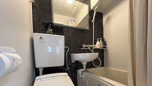 A modern bathroom with a toilet, sink, and bathtub. - 4 min walk from the nearest station in the most prosperous town in Shinjuku City Apartment room (新宿区)
