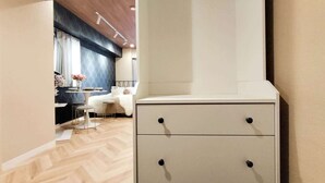 A modern bedroom with a wooden floor, a white bedside table, and a bed with a white duvet. - 4 min walk from the nearest station in the most prosperous town in Shinjuku City Apartment room (新宿区)
