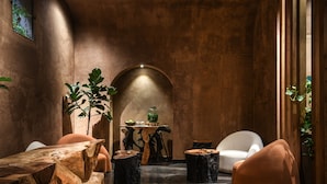 A modern interior with a wooden dining table, two chairs, a small side table, and a large plant. - Pixel Dizengoff Square - Smart Hotel by Loginn Tel Aviv (Tel Aviv)