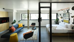 A modern living room with a sofa, chairs, a coffee table, and a bed. - Pixel Dizengoff Square - Smart Hotel by Loginn Tel Aviv (Tel Aviv)