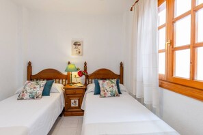 A double room with two beds, a nightstand, a lamp, and a window with curtains. - Fidalsa Feel the Sea (Guardamar)