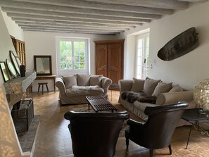 A spacious living room with two sofas, a coffee table, and a fireplace.