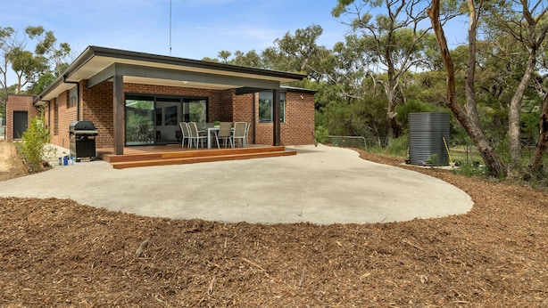 A modern house with a covered patio, a barbecue, and a large window overlooking the yard. - Chatley's (Aireys Inlet)