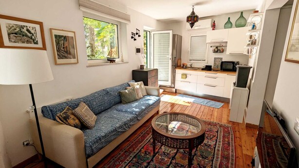 A living room with a sofa, a coffee table, and a patterned rug.