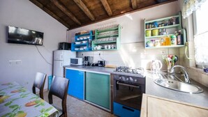 A compact kitchen with blue cabinets, a gas stove, a microwave, and a sink. - Summer House Amon (Razanac)