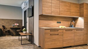 Una cocina moderna con armarios de madera, un lavaplatos empotrado y una zona de comedor con sillas y una mesa.
