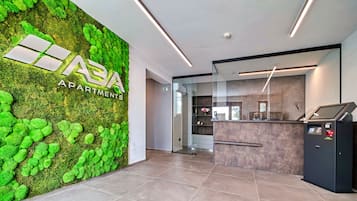 A reception area with a green moss wall, a reception desk, and a modern interior design.
