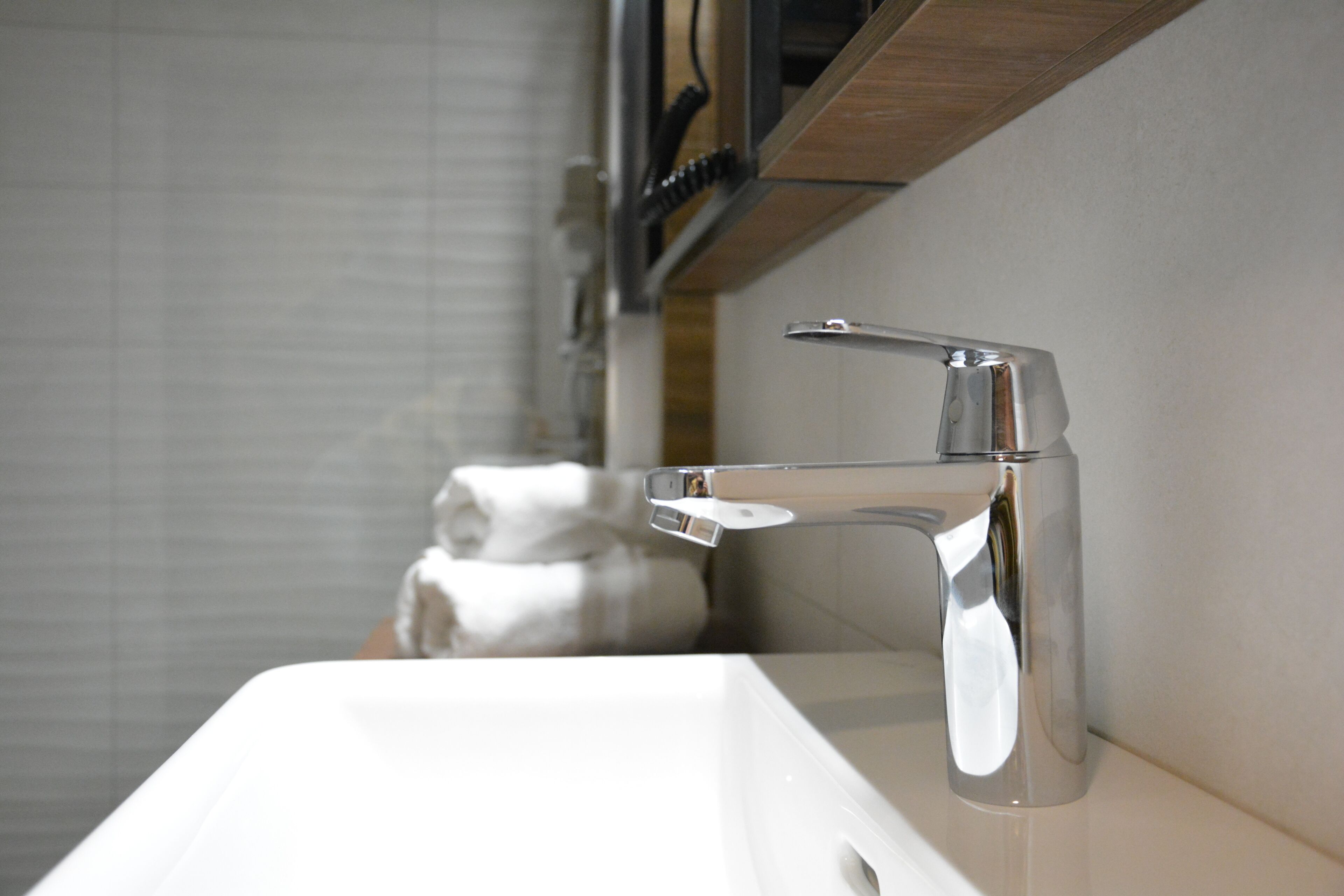 A modern bathroom with a chrome faucet and a white sink.