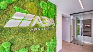Pared con textura similar al musgo y el texto "HABA APARTMENTS" en letras grandes.