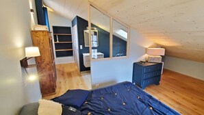 Una camera da letto con un letto, comodini, un armadio, uno specchio e una finestra.