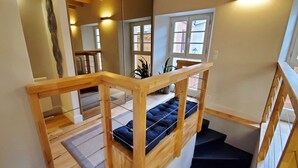 Una scala in legno con una panca imbottita all'ultimo piano.