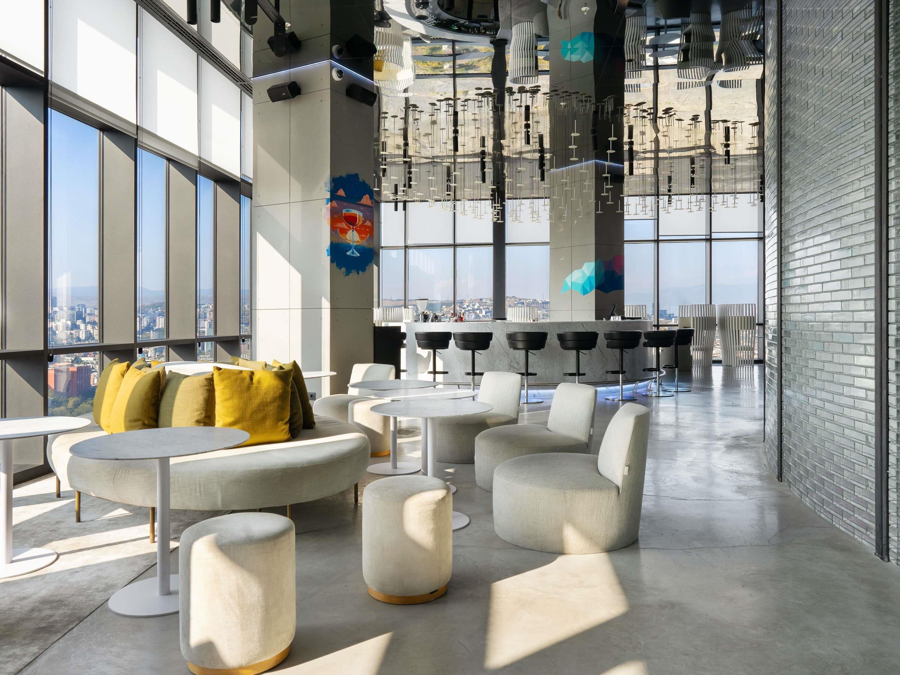 A modern interior with large windows, a bar area, and seating arrangements.