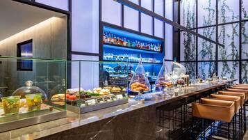 A bar area with a marble countertop, glass display cases, and a variety of food items.