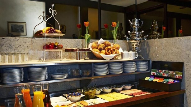 A buffet setup with various food items, including fruits, pastries, and beverages. - Stern Hotel Soller (Ismaning)