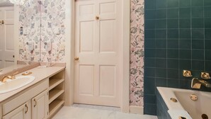 A bathroom with two sinks, a bathtub, and floral wallpaper. - Victorian Mansion Jim-Dandy Suite (Bennington)