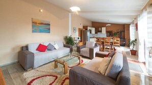 A modern living room with a grey sofa, a brown sofa, and a glass coffee table. There is a painting on the wall and a plant in the corner. - Six Bedroom Villa with Pool (Kaštel Stari)