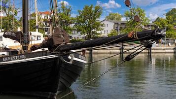 Un bote negro llamado 'ERNESTINE' atracado en un puerto deportivo con un amarre de cadena.
