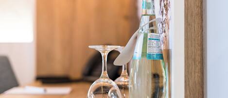 Ein Holztisch mit einer Wasserflasche, einem Glas und einem Messer.