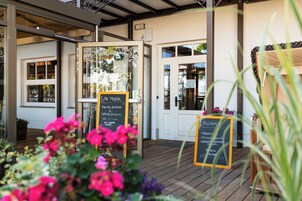 Un restaurante con terraza, un menú en pizarra y un cartel anunciando eventos de música en vivo.