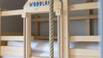 En træhusseng med køjeseng og et reb bundet til sengegavl, med teksten 'WOODLAI'.
