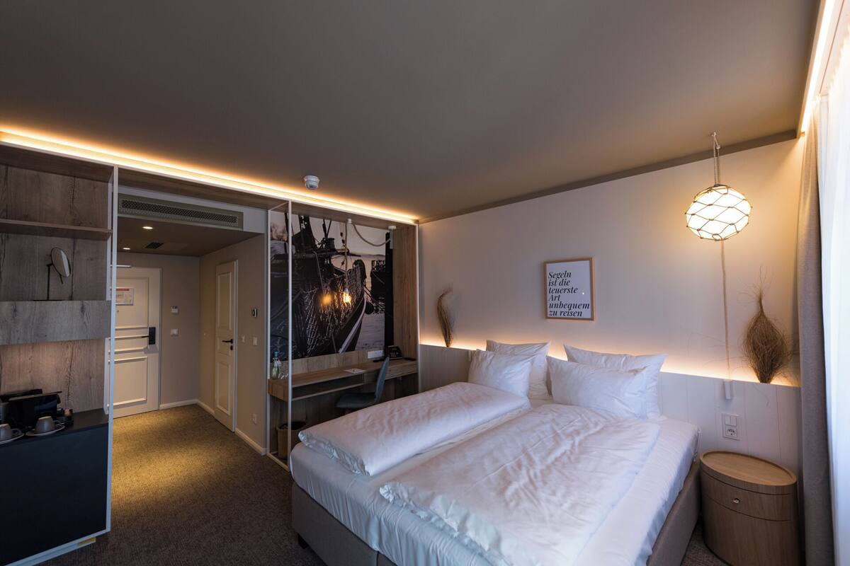 A bedroom with a bed, bedside tables, a wardrobe, and a mirror.