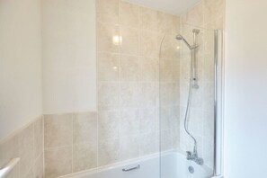 Bathtub, hair dryer, towels, shampoo