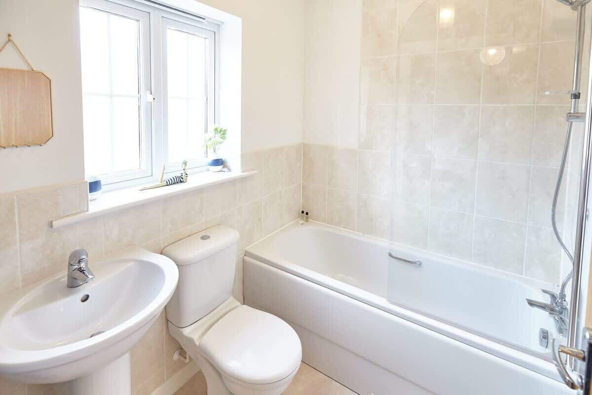 Bathtub, hair dryer, towels, shampoo