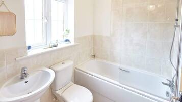Bathtub, hair dryer, towels, shampoo
