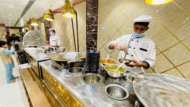 Un buffet avec plusieurs stands de nourriture, dont un stand intitulé « Aloo Tikki ».