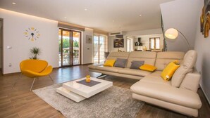 Un salon moderne avec un canapé, des fauteuils et une table basse.