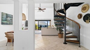 A modern interior with a spiral staircase, a dining area, and a view of the outdoors. - Hanalei Bay Resort 43212 By Parrish Kauai - Premier Interior with AC and Views (Princeville)