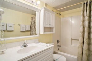 A bathroom with a white sink, mirror, and cabinet, a toilet, and a shower with a curtain. - 0710 Waters Edge Resort 1 Bedroom Condo by RedAwning (Murrells Inlet)
