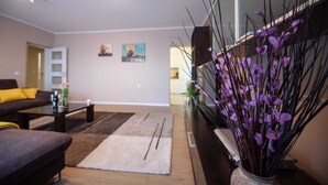 Una sala de estar moderna con sofá, mesa de centro y plantas decorativas.