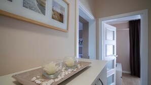 Una habitación con un mostrador blanco, dos velas en candelabros y una bandeja de madera con piedras blancas.