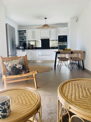 Cozy living space with a comfortable seating area, dining table for four, and a well-equipped kitchen.