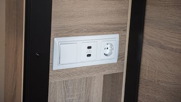 A wall-mounted electrical outlet with two USB ports and a standard plug socket.