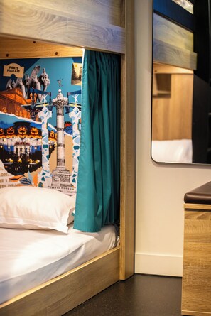 A bed with a teal curtain, a wooden headboard, and a wall with a Paris-themed poster. - The People Paris Marais (Paris)