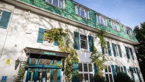 A two-story building with green-tiled roofs, white walls, and blue shutters. - THE GROVE HOTEL (Bournemouth)