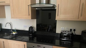 Une cuisine de taille réduite équipée d’une cuisinière à gaz, d’un four et d’un grille-pain.