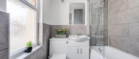 Bathtub, hair dryer, towels, toilet paper