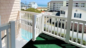 Ein Balkon mit Blick auf das Meer und andere Gebäude.